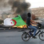 Un Palestinien arborant le drapeau algérien. D. R.