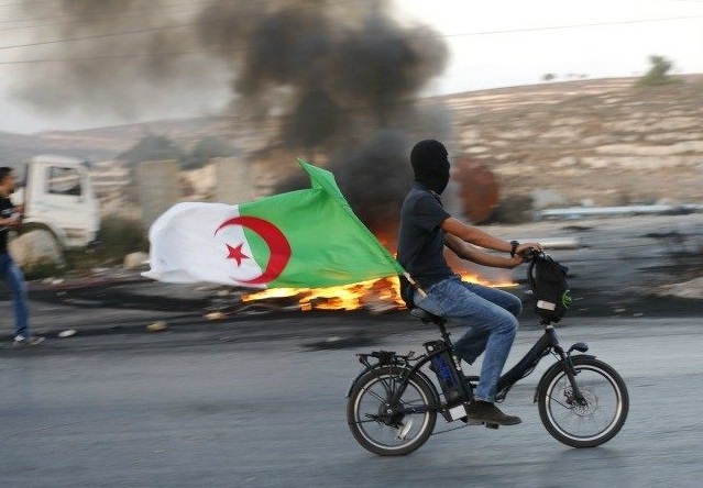 Un Palestinien arborant le drapeau algérien. D. R.