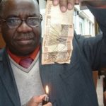 Nicolas Agbohou s'apprête à brûler un billet de banque en franc CFA. D. R.