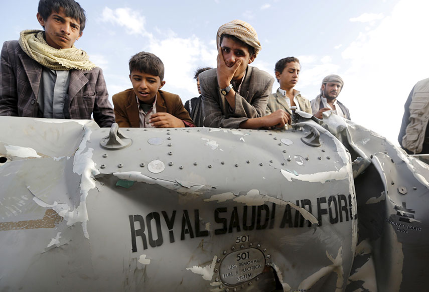 Des Yéménites devant l'épave d'un bombardier de l'armée de l'air saoudienne. D. R.