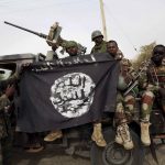 Des soldats de l'armée nigérienne tiennent un drapeau du groupe terroriste Boko Haram. D. R.